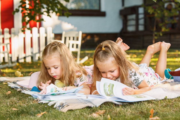 Girls read books on the grass