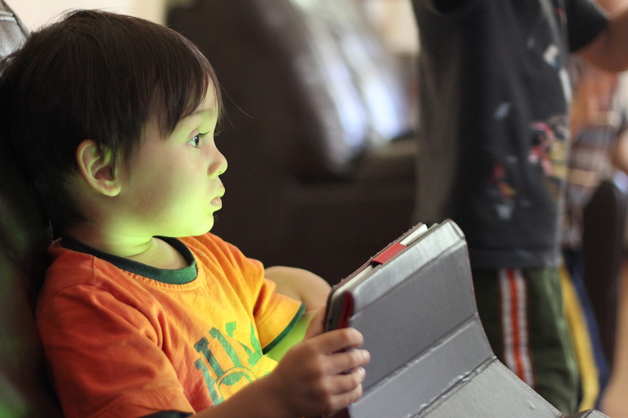 The boy uses a touch-screen tablet