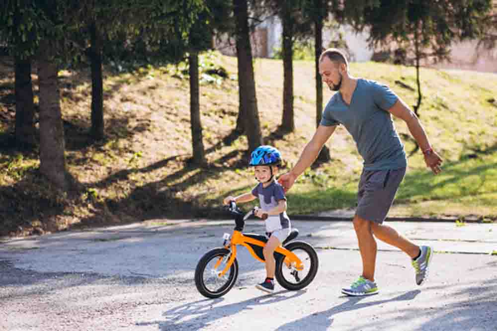 Father teachs his little son to ride a bicycle, photo credit sanivpetro