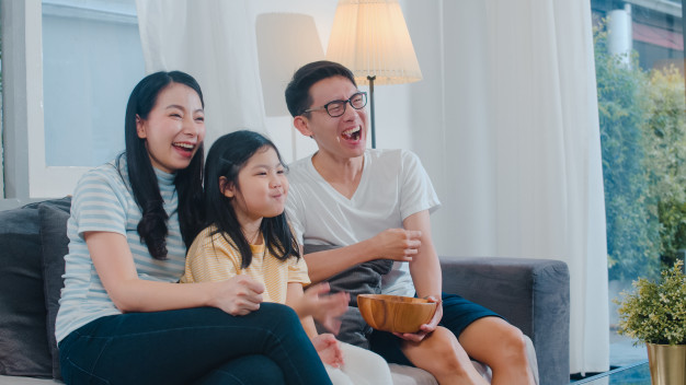 The family enjoys watching TV together, Freepik