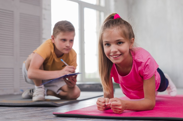 Boy writing number while girl exercising, Freepik