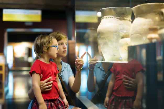 Mother and child are looking an old amphores in museum